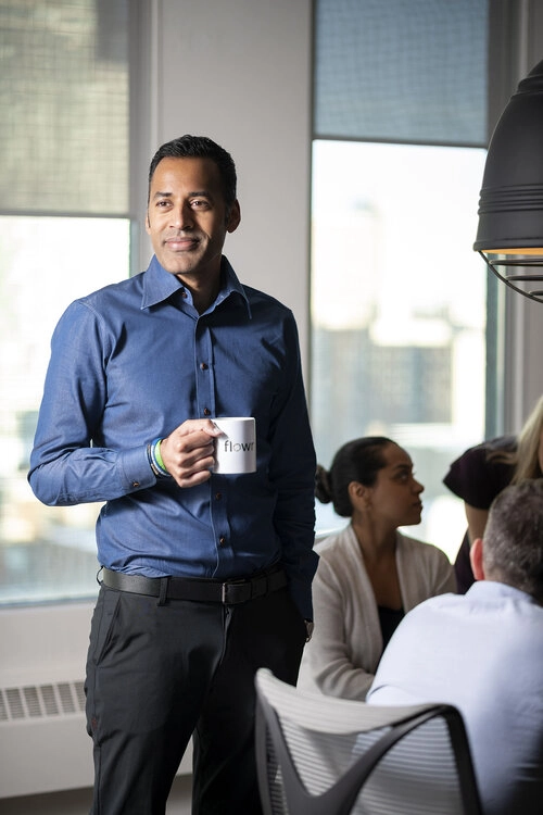 A business executive holds a cup of coffee inside a corporate boardroom