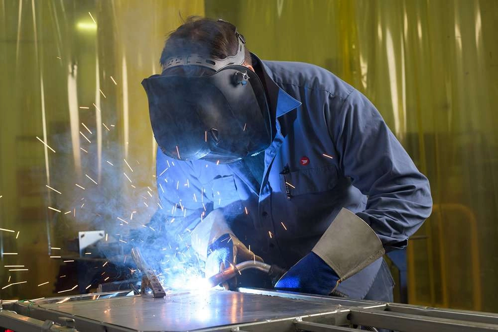 A welder uses a welding machine to join two pieces of metal together