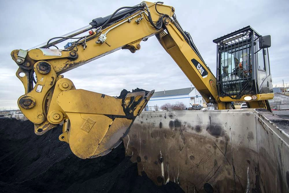 Machine empties rai car of coal