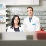 Photo of two pharmacy workers at counter