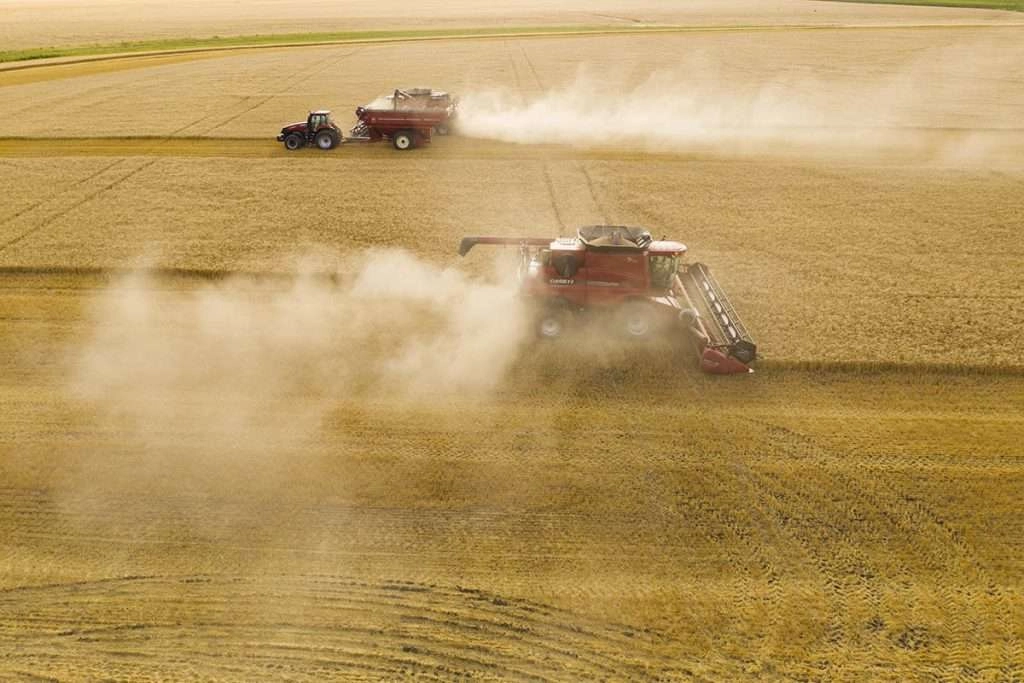 Pulverized straw is ejected from the back of the machine creating the dust clouds. © robert lowdon