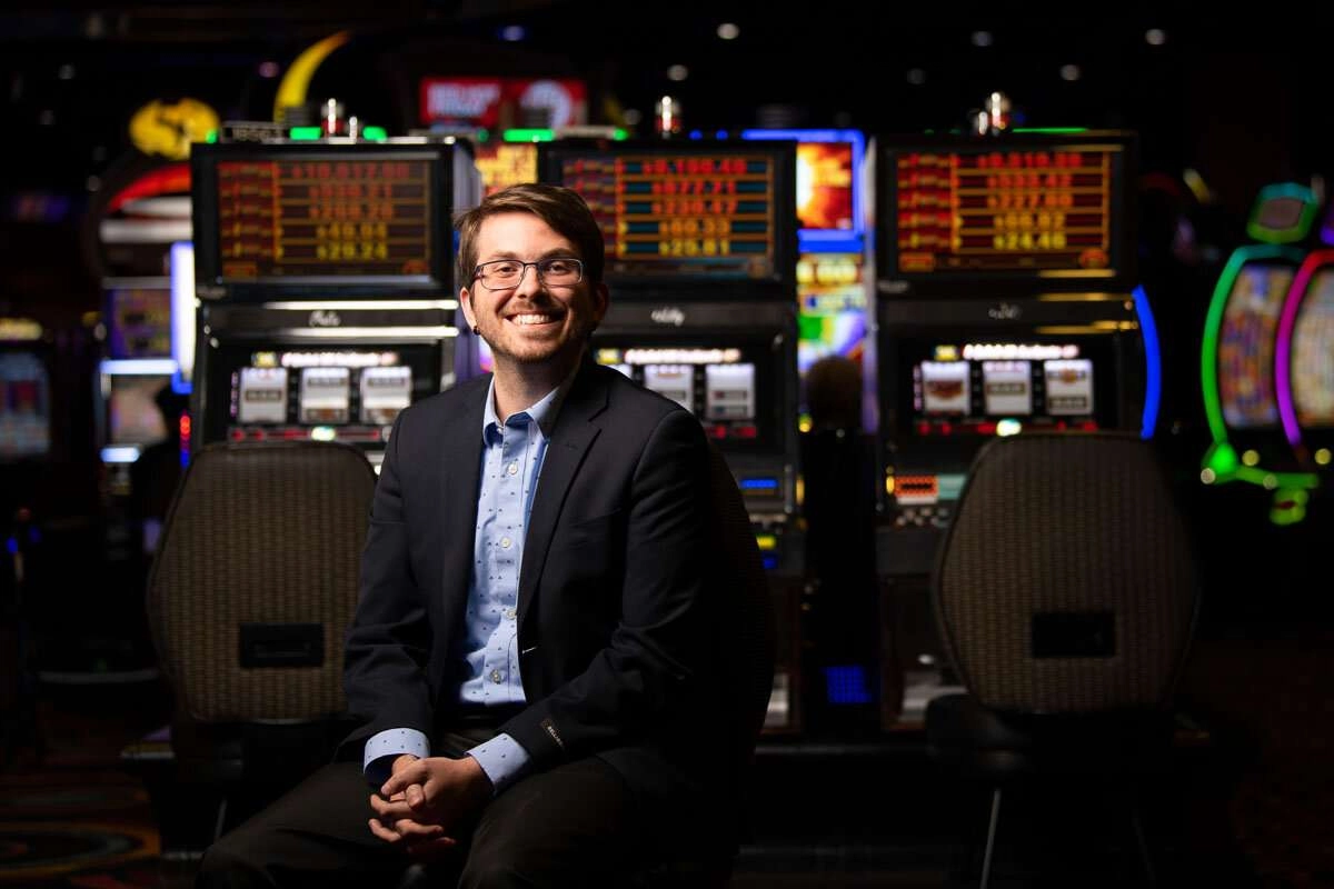 Casino executive poses for photo in front of vlts