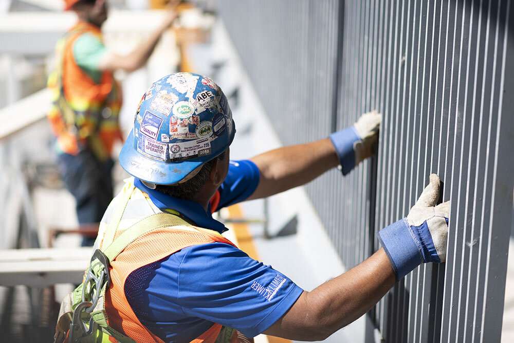 Workers attach steel railings. ©robert lowdon