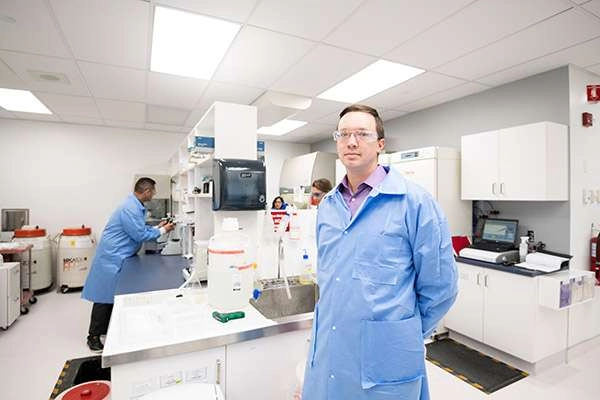 A lab technician posing in the center of the lab.