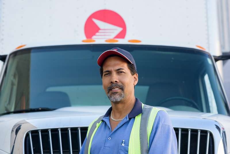 A truck driver in front of canada post vehicle. Placing the driver directly in front of the truck gave a meaningful image.