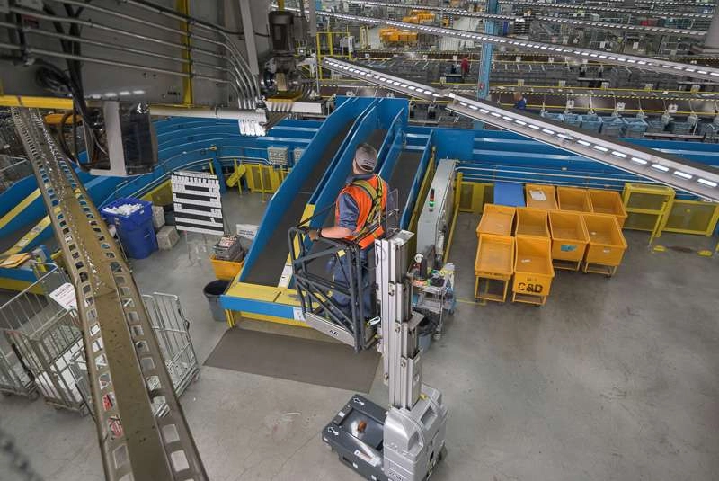 A maintenance worker inspects a conveyor belt motor. I wanted to show the sheer size of the mail plant in comparison to the worker in this image.