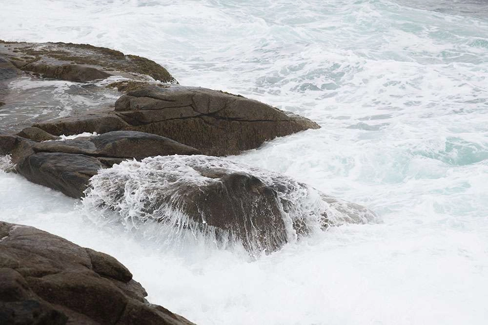 Waves crashing over rocks in nova scotia. © robert lowdon