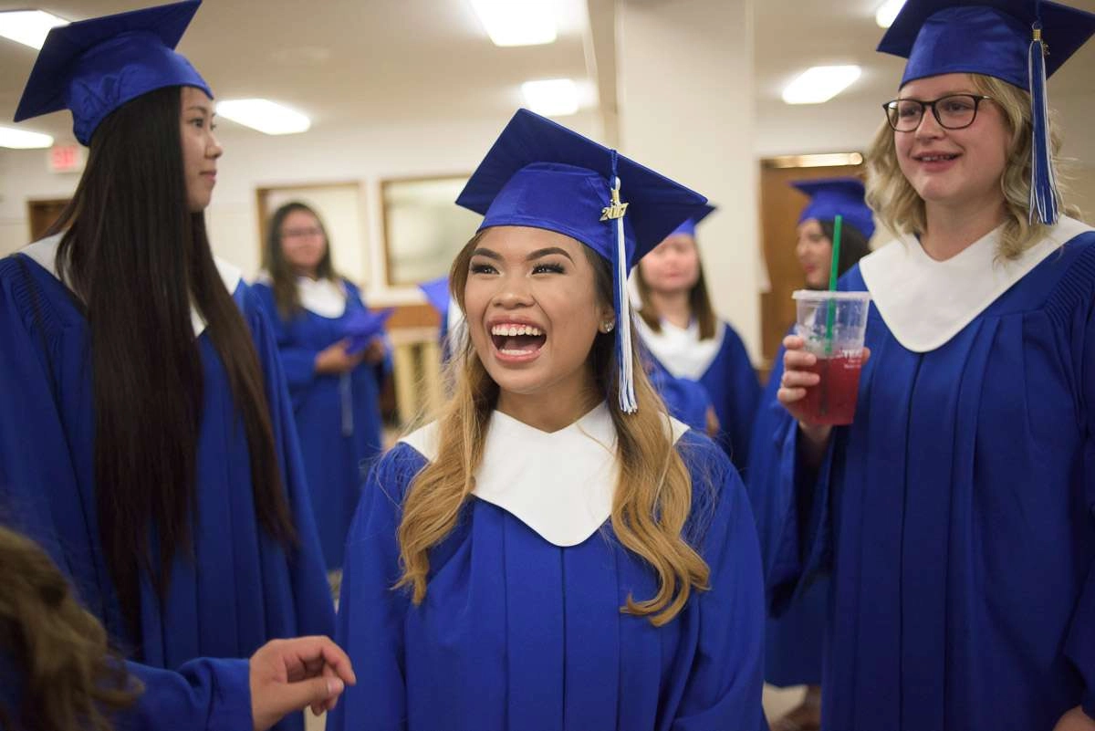 This candid image captures a group of graduates sharing in a laugh following the ceremony. The smiling faces help to convey the exuberance of the day.