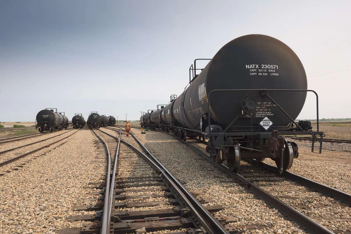 Industrial railway photography of a rail worker prepares to move oil cars in a storage yard