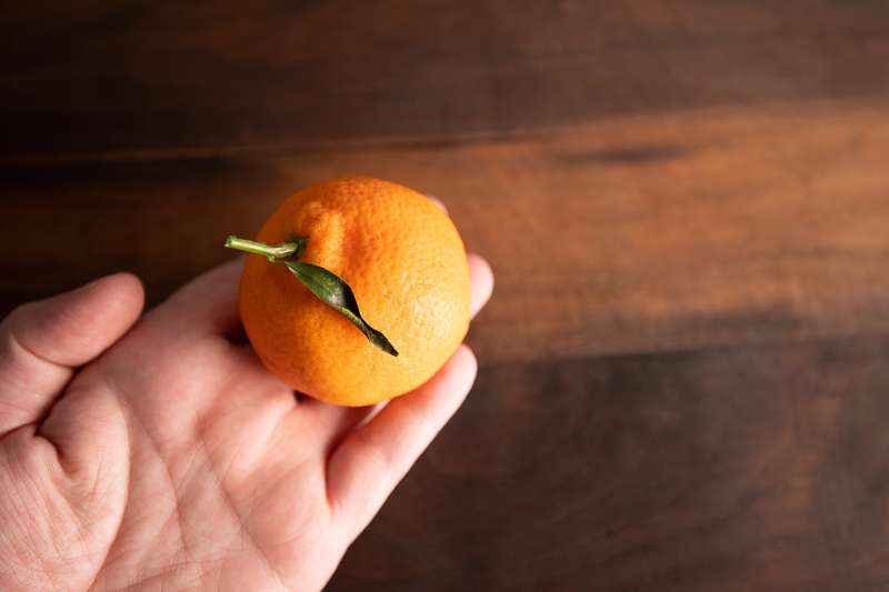 Holding the orange over a board