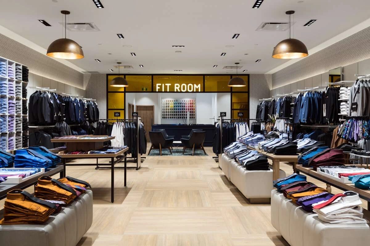 View of the fit room with shirts in the foreground.