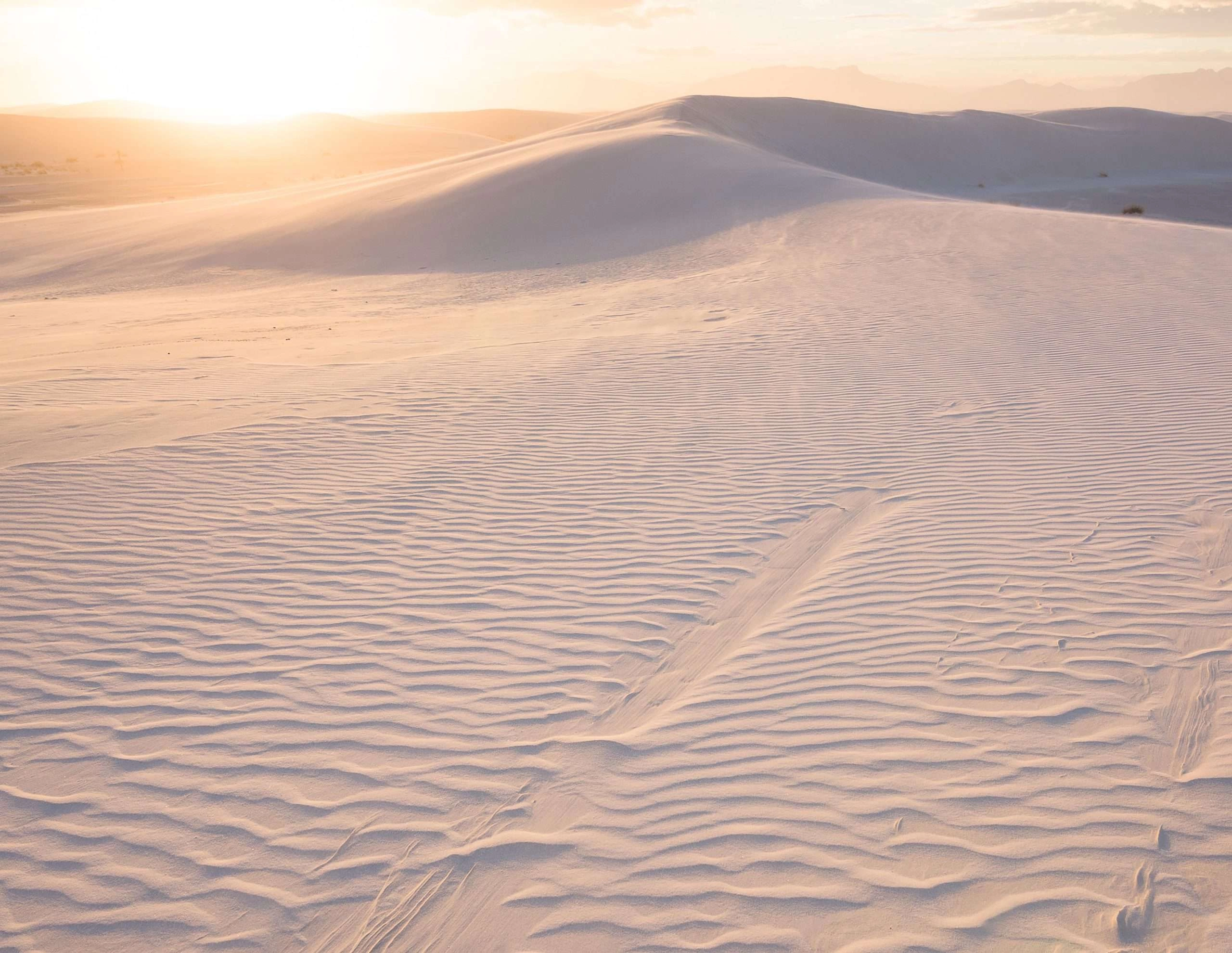 The sunsets across the white sand of white sands.