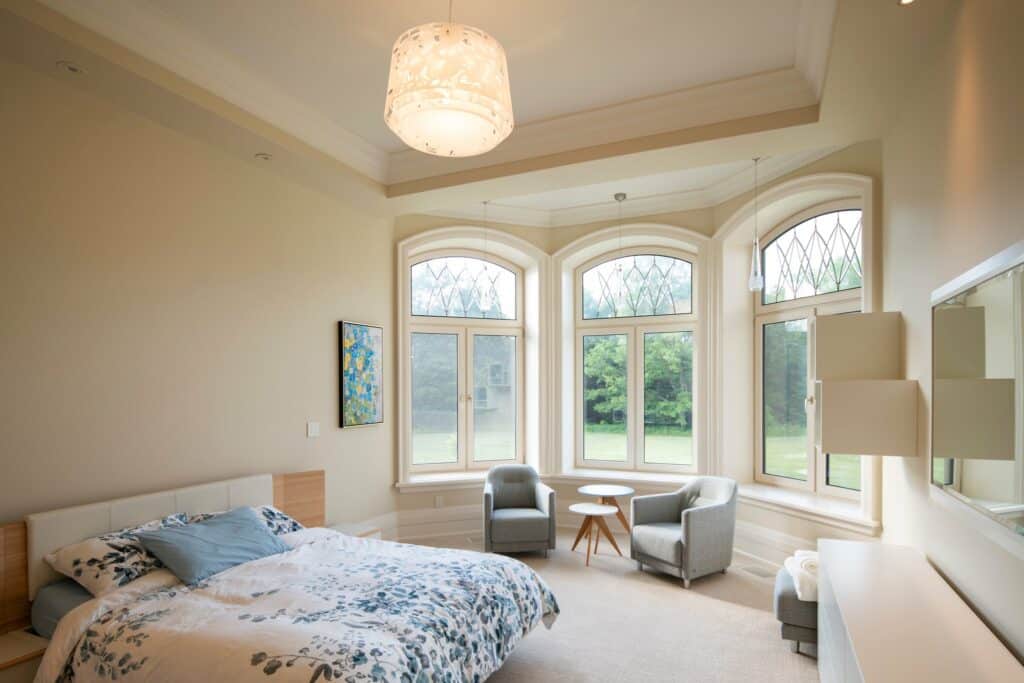 Delicate light fixture with intricate design in a bedroom with bay windows