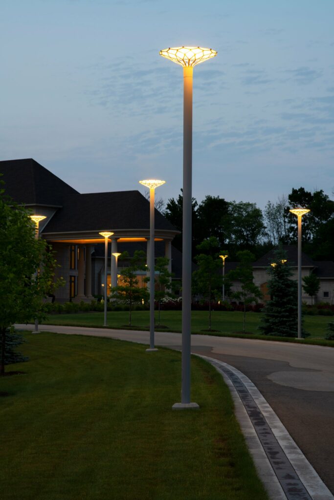 Exterior light fixtures bordering the driveway at dusk