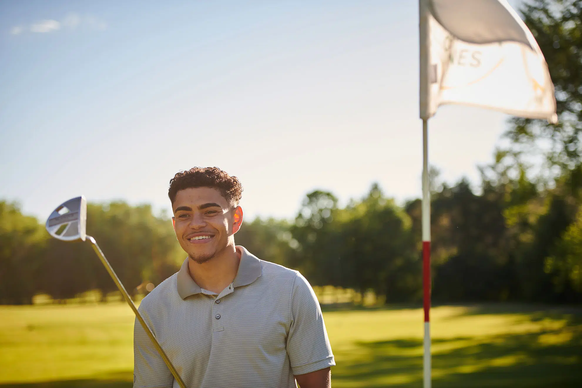 Candid image of young male golfer on green