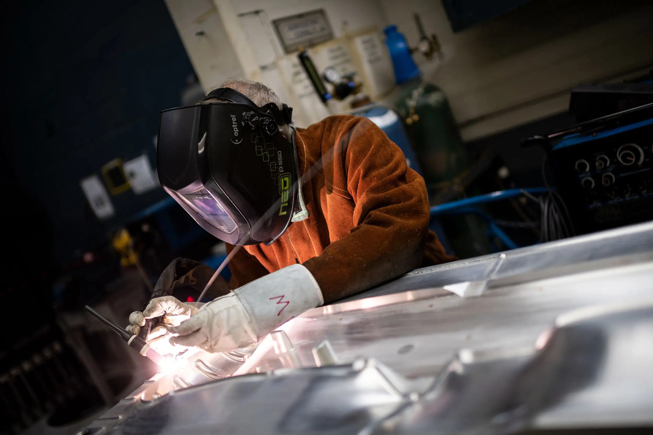 A welder is repairing an aluminum mold.