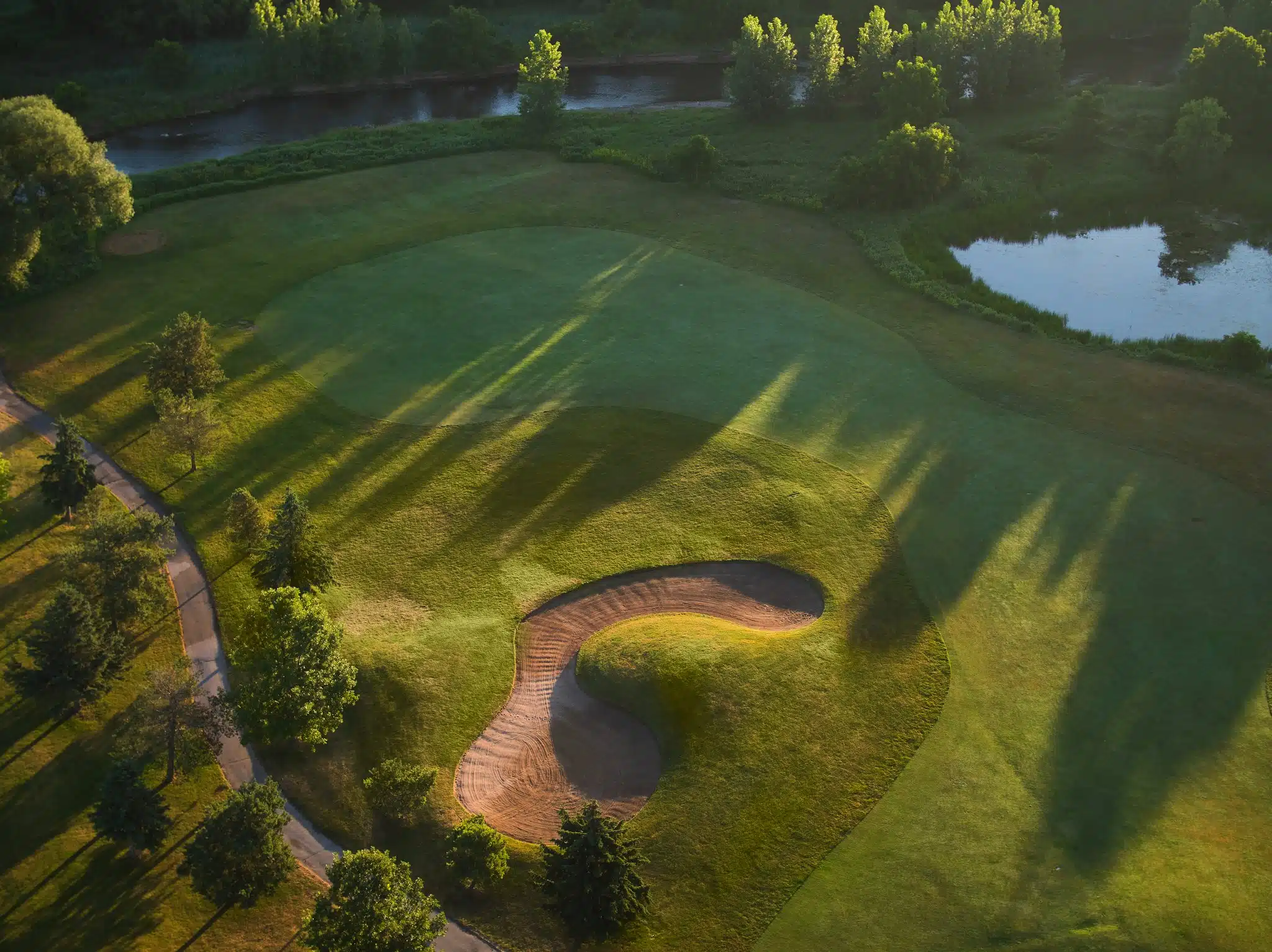 Aerial image of sand trap with water features in the background.