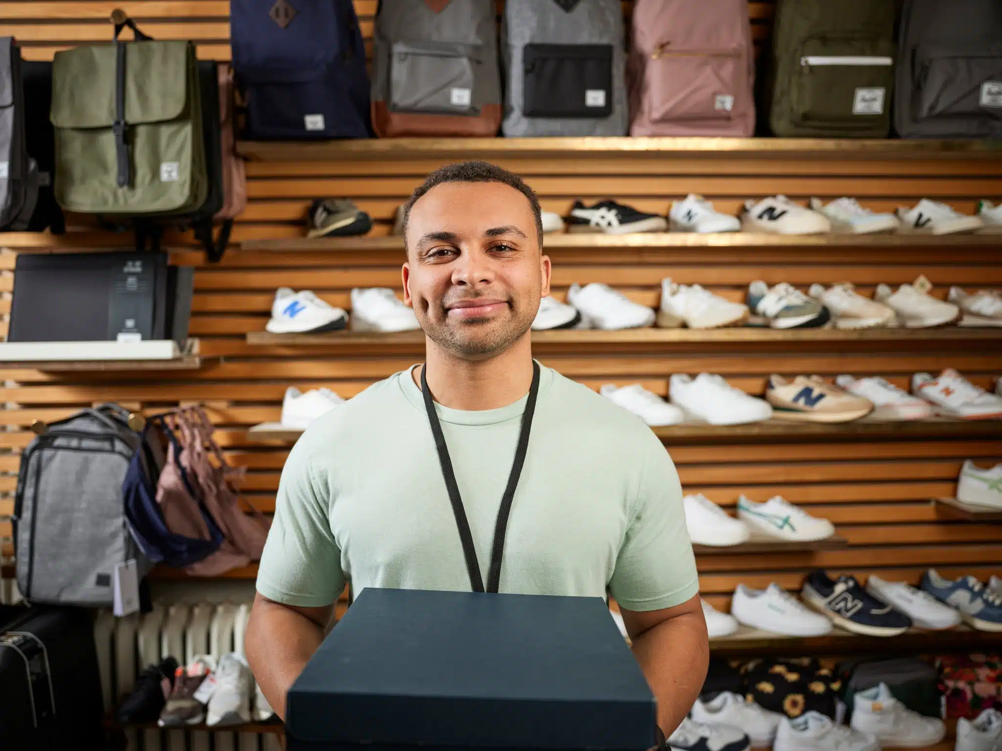 Rebranding image showcasing employee in shoe section of retail store.